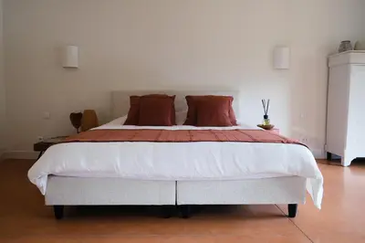 a bedroom with a large bed with red pillows at Louis Henry in Saint-Pierre-des-Champs