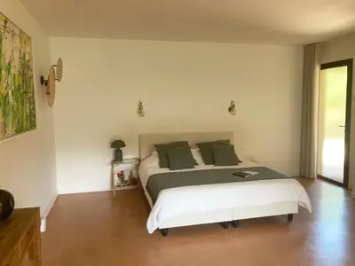 a bedroom with a large bed with green pillows at Louis Henry in Saint-Pierre-des-Champs