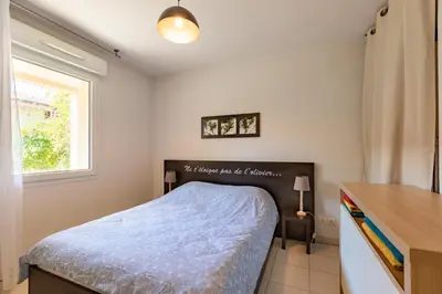 a bedroom with a bed and a desk and a window at Le Clos d'Azille - Appt pour 6 personnes in Azille