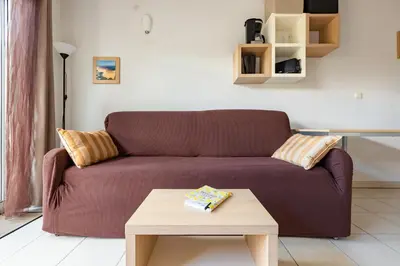 a living room with a brown couch and a coffee table at Le Clos d'Azille - Appt pour 6 personnes in Azille