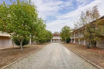 an empty road in front of a building with trees at Le Clos d'Azille - Appt pour 6 personnes in Azille