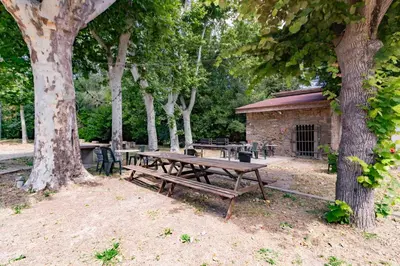 a picnic table in a park next to trees at Le Clos d'Azille - Appt pour 6 personnes in Azille