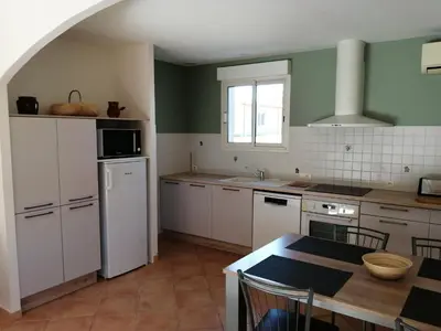 a kitchen with white cabinets and a table in it at GITE CHEZ JULES ET ODETTE in Comigne