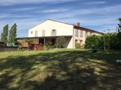 a large white house in a yard with a grass field at domaine en castanet in Caraman