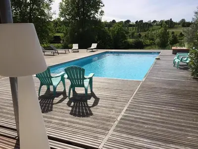 two chairs and a swimming pool on a deck at domaine en castanet in Caraman