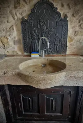 a sink in a bathroom with a stone wall at Le Domaine de Pépé in Saint-Julien-de-Briola