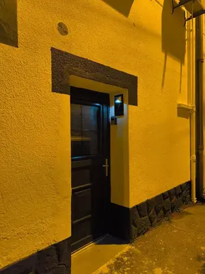 a black door in the side of a yellow building at agréable studio in Narbonne