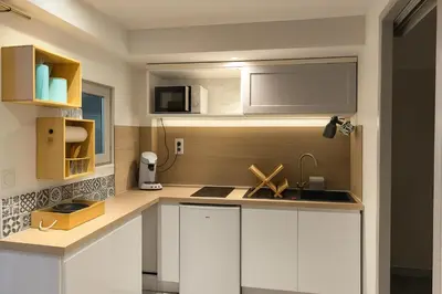 a kitchen with white cabinets and a sink at agréable studio in Narbonne