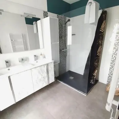 a white bathroom with two sinks and a shower at Villa 