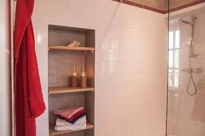 a bathroom with a shower and a red towel at Château de la Motte - Entre Narbonne et le Canal du Midi in Marcorignan