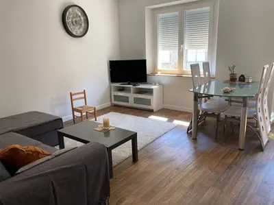 a living room with a table and a dining room at La tranquillité en centre-ville avec terrasse in Limoux