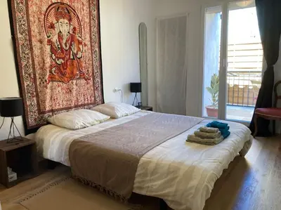 a bedroom with a bed with a large painting on the wall at La tranquillité en centre-ville avec terrasse in Limoux