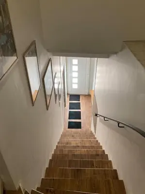 a staircase in a building with some pictures on the wall at La tranquillité en centre-ville avec terrasse in Limoux