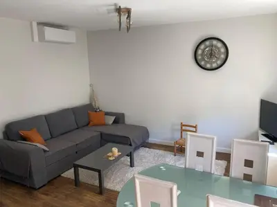 a living room with a couch and a table at La tranquillité en centre-ville avec terrasse in Limoux