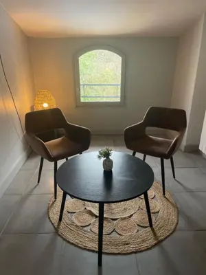 a living room with two chairs and a coffee table at La Tuilerie du Bazalac in Trèbes