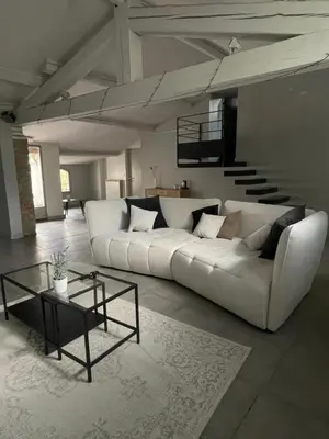 a living room with a white couch and a table at La Tuilerie du Bazalac in Trèbes