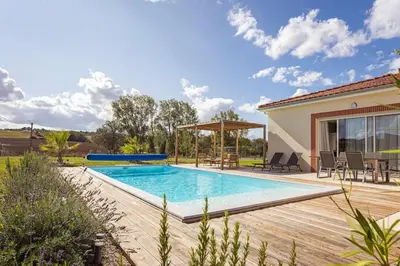 a swimming pool in a yard with a house at Maison charme et confort - piscine chauffée in Tarabel