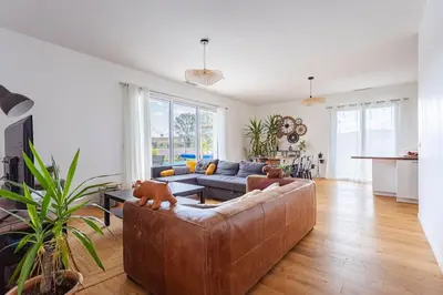 a living room with a brown leather couch in a room at Maison charme et confort - piscine chauffée in Tarabel