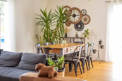 a living room with a table and some plants at Maison charme et confort - piscine chauffée in Tarabel