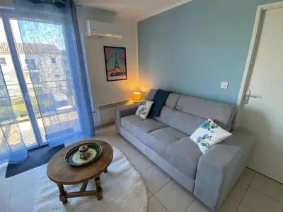 a living room with a couch and a coffee table at Le Voyage Bleu, Clim Parking in Carcassonne