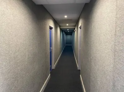 a long hallway with a blue door in a building at Le Voyage Bleu, Clim Parking in Carcassonne