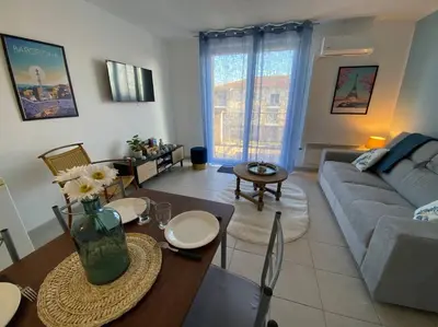 a living room with a couch and a table at Le Voyage Bleu, Clim Parking in Carcassonne