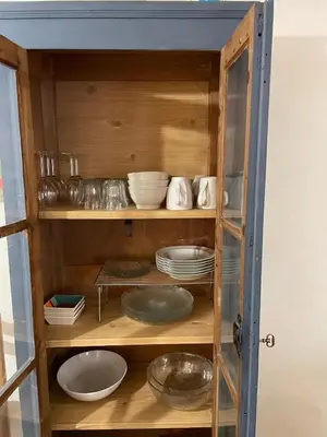 a wooden cabinet with plates and bowls in it at Le Careyrou in Paziols