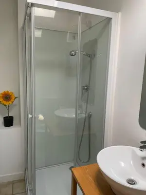 a glass shower in a bathroom with a sink at Le Careyrou in Paziols