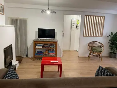 a living room with a couch and a table and a tv at Le Careyrou in Paziols