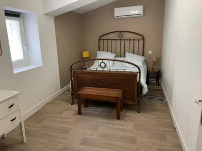 a bedroom with a bed with a wooden foot board at Le Careyrou in Paziols