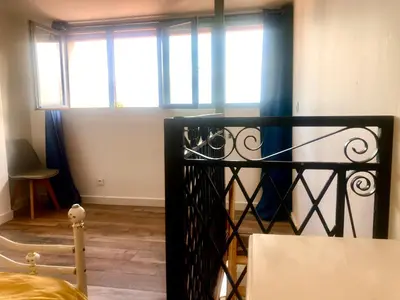 a bedroom with a black iron gate and windows at 