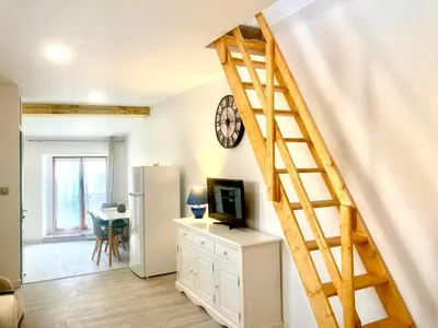 a living room with a staircase with a television and a refrigerator at 