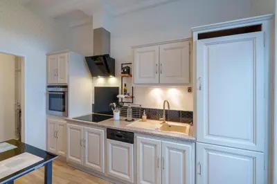 a kitchen with white cabinets and a sink at Le petit coin de la bastide 11 in Carcassonne