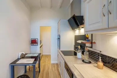 a kitchen with white cabinets and a counter top at Le petit coin de la bastide 11 in Carcassonne