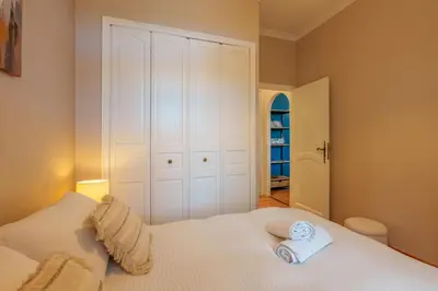a bedroom with a white bed with two towels on it at Le petit coin de la bastide 11 in Carcassonne