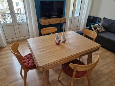 a wooden table and chairs in a living room at Le petit coin de la bastide 11 in Carcassonne