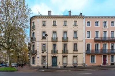 a large building on the side of a street at Le petit coin de la bastide 11 in Carcassonne