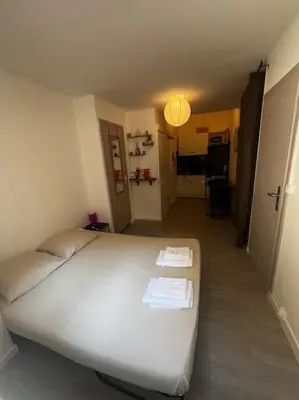 a bedroom with a white bed with two towels on it at Studio Distillerie in Narbonne