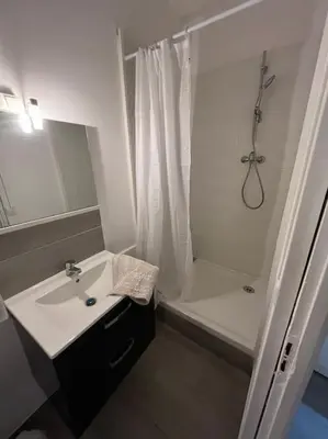 a white bathroom with a sink and a shower at Studio Distillerie in Narbonne