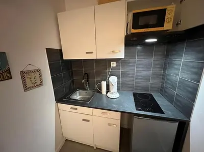 a small kitchen with a sink and a microwave at Studio Distillerie in Narbonne