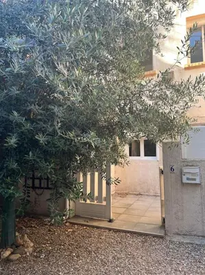 a tree in front of a building with a door at Studio Distillerie in Narbonne