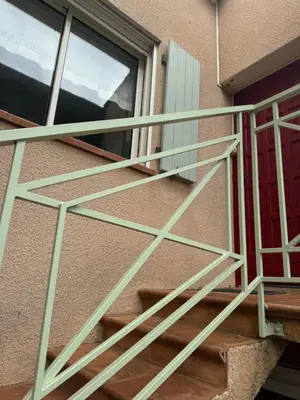 a metal staircase on a building next to a window at la vue des étangs in Bages