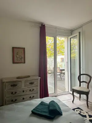 a bedroom with a bed and a dresser and a sliding glass door at la vue des étangs in Bages