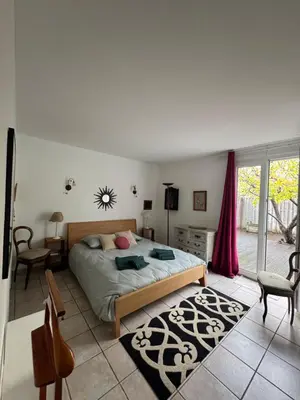a bedroom with a bed and a table and chairs at la vue des étangs in Bages