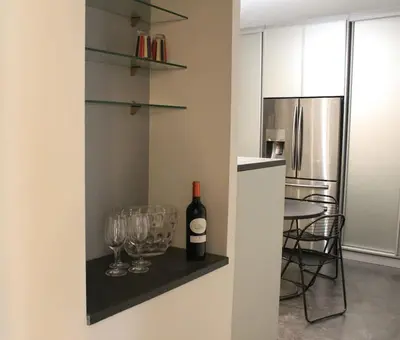 a bottle of wine and glasses on a shelf in a kitchen at Gorgeous 5 bedroom villa with air con, heated pool and garden for 12 in Villemoustaussou