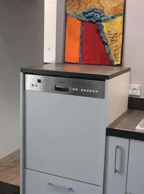 a painting is sitting on top of a dishwasher at Gorgeous 5 bedroom villa with air con, heated pool and garden for 12 in Villemoustaussou