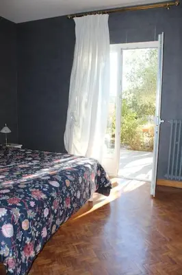 a bedroom with a bed and a sliding glass door at Gorgeous 5 bedroom villa with air con, heated pool and garden for 12 in Villemoustaussou