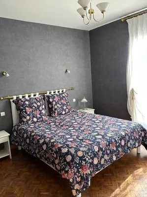 a bedroom with a bed with a floral bedspread at Gorgeous 5 bedroom villa with air con, heated pool and garden for 12 in Villemoustaussou