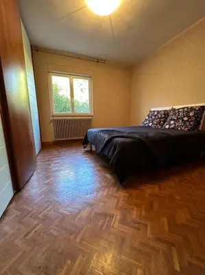 a bedroom with a bed and a wooden floor at Gorgeous 5 bedroom villa with air con, heated pool and garden for 12 in Villemoustaussou