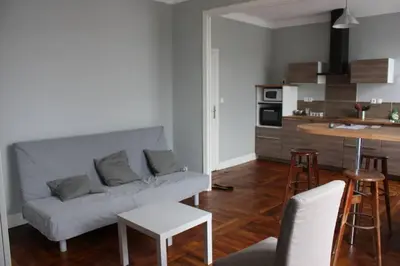 a living room with a couch and a kitchen at T2 Gautier proche Cité Médiévale parking privé in Carcassonne